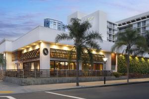 a building with a palm tree in front of it at Courtyard by Marriott Long Beach Downtown in Long Beach