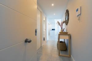 a hallway with a door and a table with a mirror at Doña Julia Sea Utopia in Casares +30 photos