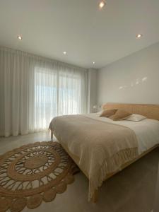 a bedroom with a large bed and a large window at Doña Julia Sea Utopia in Casares
