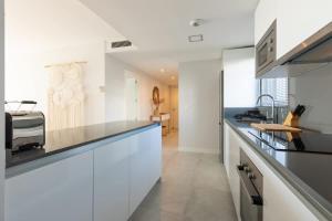 a kitchen with white cabinets and a counter top at Doña Julia Sea Utopia in Casares