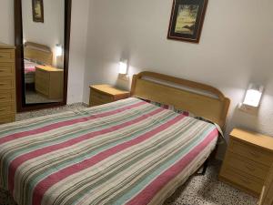 a bedroom with a bed and a large mirror at RIU MAR Apartment Cullera in Cullera
