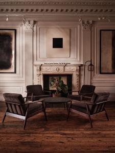 a living room with two chairs and a fireplace at The Columbia in London
