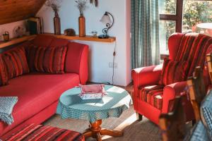 a living room with a red couch and two chairs at Kauperhaus in Burg