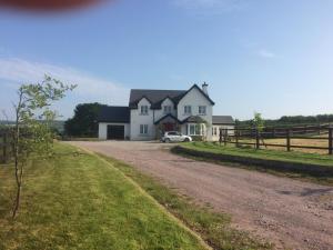 a house with a car parked in front of a dirt road at Hunthill in Tulach an Iarainn