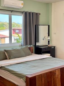 a bedroom with a bed with a mirror and a window at Pai Local Apartment in Pai