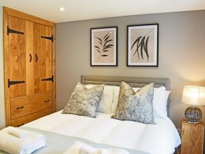 a bedroom with a white bed with two pillows at 14 Doomgate House - Uk45055 in Appleby