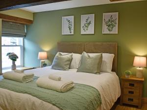 a bedroom with a large bed with green walls at 14 Doomgate House - Uk45055 in Appleby