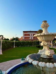 a fountain in a park with a building in the background at Fruit Village Capo Rizzuto S Antonio in Capo Rizzuto