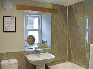 a bathroom with a sink and a toilet and a mirror at 14 Doomgate House - Uk45055 in Appleby +4 photos