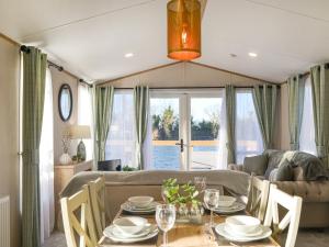 a dining room and living room with a table and chairs at Waterfoot Lodge W09 in Amotherby