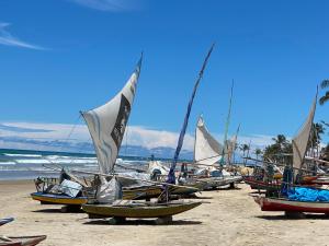 a group of boats sitting on the beach at Casa Bosque Guajiru in Trairi