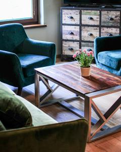 a living room with a coffee table and chairs at Janowe Wzgórze in Cieszyna
