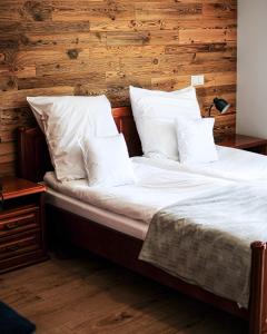 a large bed with white sheets and pillows at Janowe Wzgórze in Cieszyna