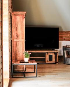 a large entertainment center with a tv and a table at Janowe Wzgórze in Cieszyna