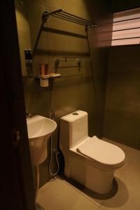 a bathroom with a white toilet and a sink at Majesty inn in Bangalore