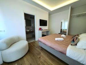 a bedroom with a bed and a chair in it at Riviera Suites - by Be Your Home in Civitavecchia
