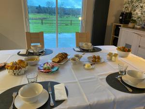 a table with a white table cloth with food on it at Chambres d'hôtes de l'Eau dit Sée in Cuves