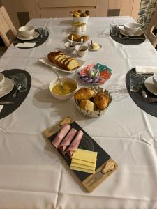 a table with a white table cloth with food on it at Chambres d'hôtes de l'Eau dit Sée in Cuves +25 photos