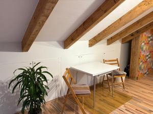 a white table and chairs in a room with wooden floors at Delfinia in Althegnenberg