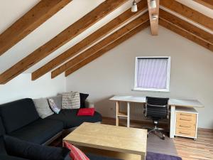 a living room with a couch and a desk at Delfinia in Althegnenberg