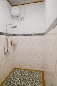 a bathroom with white marble walls and a shower at Eric Dolphin Villa in Lovina +27 photos