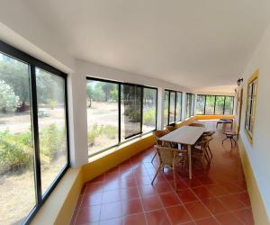 a room with a table and chairs and windows at Markádia in Alvito