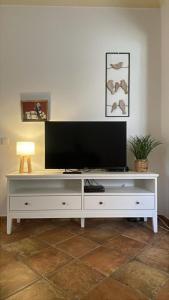 a white entertainment center with a flat screen tv on top at Markádia in Alvito