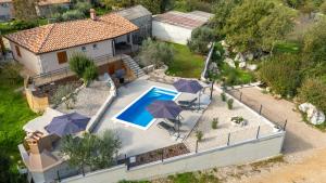 an aerial view of a house with a swimming pool and umbrellas at House Cerovac in Nedeščina