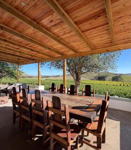 a large wooden table and chairs under a wooden ceiling at Windkraal Farm House in Bonnievale