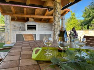 a table with wine glasses and a bottle on it at Apartment House Liznjan in Ližnjan