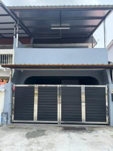 a garage door with a gate in front of a house at Sweet Homestay Bahau in Bahau