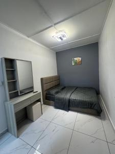a small bedroom with a bed and a television at Sweet Homestay Bahau in Bahau