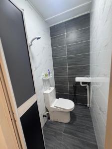 a small bathroom with a toilet and a sink at Sweet Homestay Bahau in Bahau +12 photos