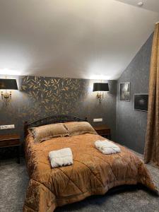 a bedroom with a large bed with two towels on it at Шале Вершина in Palyanytsya