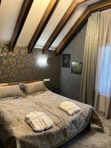 a bedroom with a bed with two pillows on it at Шале Вершина in Palyanytsya