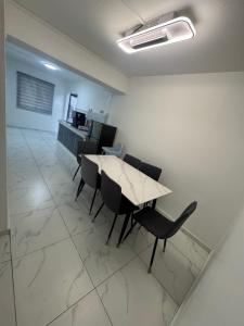 a dining room with a table and chairs in a room at Sweet Homestay Bahau in Bahau