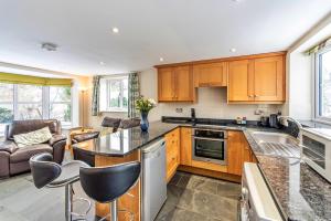 a kitchen with wooden cabinets and a counter top at Finest Retreats - Cedar Tree Cottage in Clocaenog