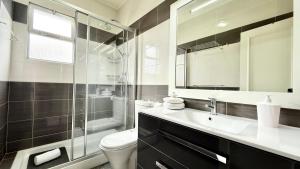 a bathroom with a toilet and a sink and a shower at The Gray House in Bicas +25 photos