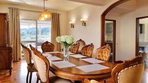 a dining room with a wooden table and chairs at The Gray House in Bicas