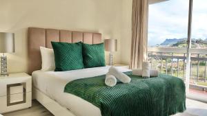 a bedroom with a green and white bed with a window at The Gray House in Bicas