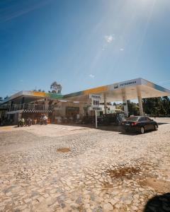 a car parked in front of a gas station at Hotel Rota 090 in Piraí do Sul