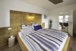 a bedroom with a large bed with a wooden wall at Die Blaue Pause 42 in Weißenstadt