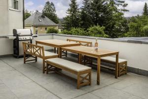 a patio with two tables and chairs and a grill at Die Blaue Pause 42 in Weißenstadt
