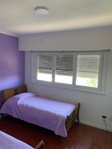 a bedroom with two beds and two windows at Casa en Miramar in Miramar +14 photos