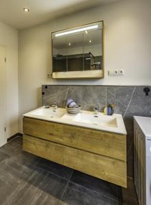 a bathroom with a sink and a mirror at Die Blaue Pause 42 in Weißenstadt +6 photos