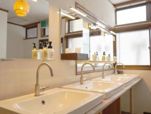 a bathroom with three sinks and a mirror at Slopeside Lodge Hakuba in Otari +39 photos