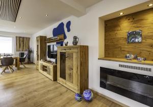 a living room with a fireplace and a wooden wall at Die Blaue Pause 42 in Weißenstadt