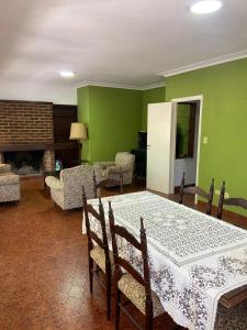 a dining room with a table and chairs and green walls at Casa en Miramar in Miramar