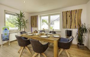 a dining room with a wooden table and chairs at Die Blaue Pause 42 in Weißenstadt