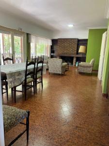 a dining room with a table and chairs and a fireplace at Casa en Miramar in Miramar